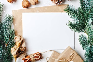 Mutlu Noeller ve mutlu yeni yıl. Mockup kartpostal ve beyaz arka plan üzerinde bir Noel ağacı dalları ile. Arka plan kopya alanı ile. Üstten görünüm. Noel arka plan. Yatay.