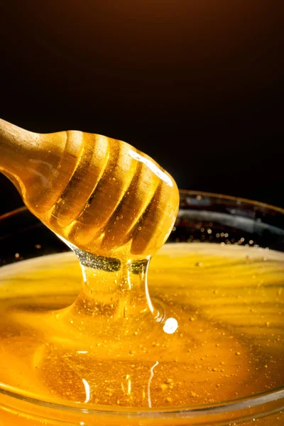 La miel con el color dorado baja de la cuchara. Concepto de comida saludable. Alimentación saludable. Dieta. Enfoque selectivo . — Foto de Stock