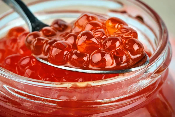 Kırmızı havyar kaşık ile cam kavanoza. Deniz ürünleri. Sağlıklı beslenme. Diyet. Shabby Chic tarzı ahşap arka plan.