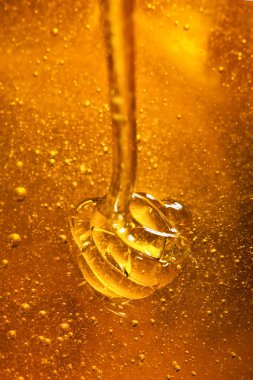 Bal ile altın rengi bir kaşık gelen aşağı akar. Sağlıklı gıda kavramı. Sağlıklı beslenme. Diyet. Seçici odak. Makro.