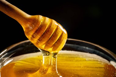 Bal ile altın rengi bir kaşık gelen aşağı akar. Sağlıklı gıda kavramı. Sağlıklı beslenme. Diyet. Seçici odak.