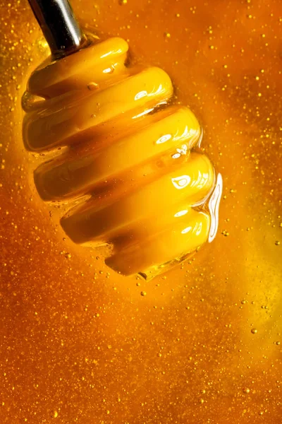 Honey with gold color flows down from a spoon. Healthy food concept. Healthy eating. Diet. Selective focus. Background with copy space.