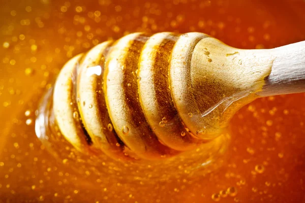 Le miel avec la couleur d'or coule vers le bas d'une cuillère. Concept d'alimentation saine. Une saine alimentation. Régime alimentaire. Concentration sélective . — Photo