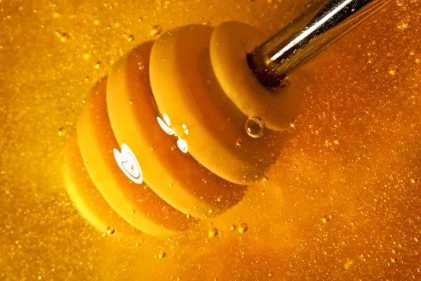 골드 색상으로 꿀 숟가락에서 아래로 흐른다. 건강 식품 개념입니다. 건강 한 먹는입니다. 다이어트입니다. 선택적 초점입니다. 배경 복사 공간. — 스톡 사진