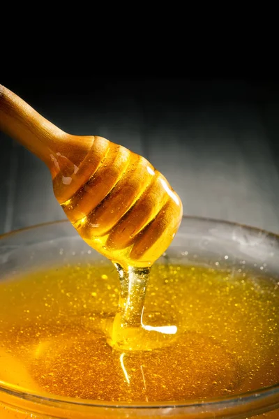 Honey with gold color flows down from a spoon. Healthy food concept. Healthy eating. Diet. Selective focus. Background with copy space.