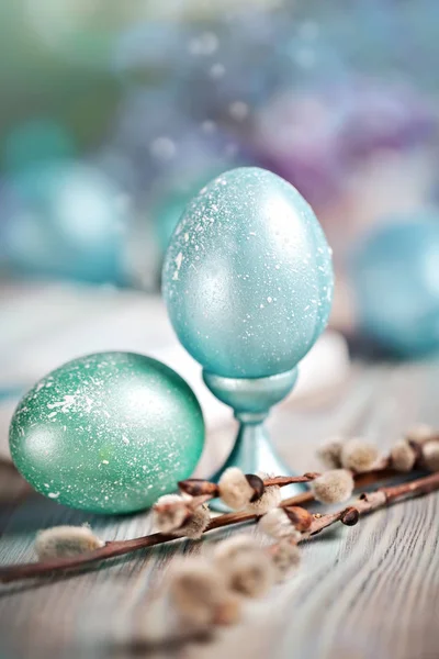 Happy Easter. Congratulatory easter background. Easter eggs and willow branches on a wooden table. Selective focus.