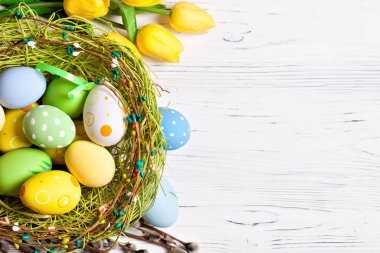 Mutlu Paskalyalar. Paskalya arkaplanını tebrik ederim. Paskalya yumurtaları ve çiçekler. Kopya alanı olan bir arkaplan. Seçici odaklanma. Üst görünüm.