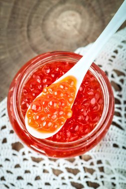 Kırmızı havyar kaşık ile cam kavanoza. Deniz ürünleri. Sağlıklı beslenme. Diyet. Shabby Chic tarzı ahşap arka plan.