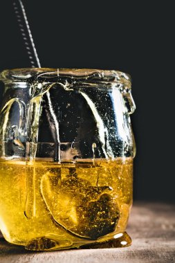 Siyah bir zemin üzerine bal ile jar. Alan metni kopyalayın. Seçici odak.