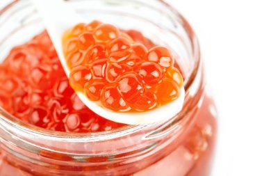 Kırmızı havyar beyaz zemin üzerine kaşık ile cam kavanoza. Deniz ürünleri. Sağlıklı beslenme. Diyet. Seçici odak.