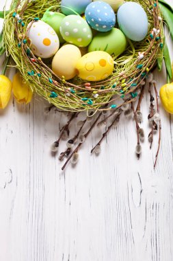 Mutlu Paskalyalar. Paskalya arkaplanını tebrik ederim. Paskalya yumurtaları ve çiçekler. Kopya alanı olan bir arkaplan. Seçici odaklanma. Üst görünüm.