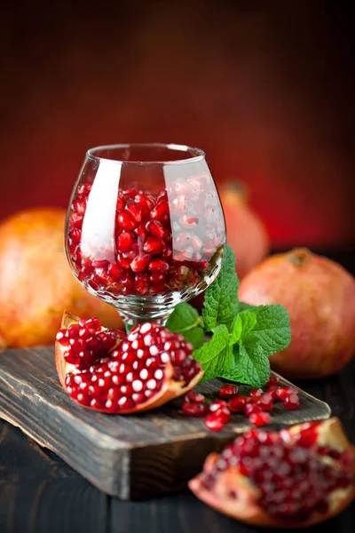 Fruta de granada madura sobre un antiguo fondo vintage de madera negra. Fondo con espacio de copia. Vertical. — Foto de Stock