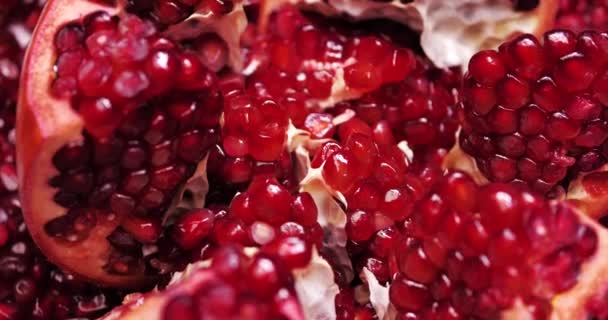 Ripe pomegranate on a dark wooden background. Slow motion. — Stock Video