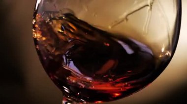 Konyak bir bardakta döndürülür. Koyu arka planda.