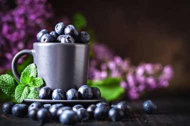 Ahududu ve yaban mersini karanlık bir arka plan üzerinde bir Fincan içinde. Yaz ve sağlıklı gıda konsepti. Kopyalama alanı ile arka plan. Seçici odak. Yatay.