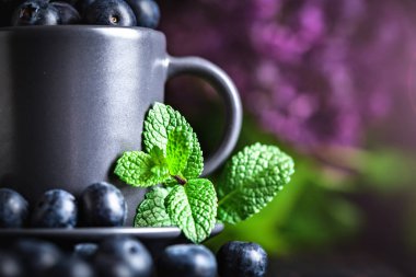 Ahududu ve yaban mersini karanlık bir arka plan üzerinde bir Fincan içinde. Yaz ve sağlıklı gıda konsepti. Kopyalama alanı ile arka plan. Seçici odak. Yatay.