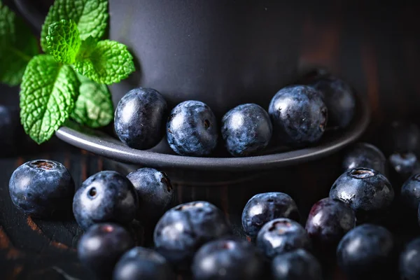 Ahududu ve yaban mersini karanlık bir arka plan üzerinde bir Fincan içinde. Yaz ve sağlıklı gıda konsepti. Seçici odak. Yatay.