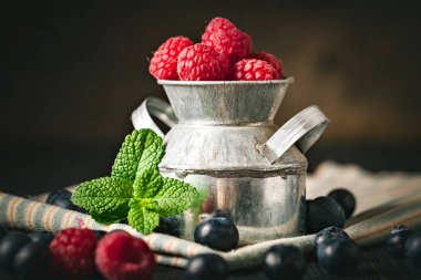 Ahududu ve yaban mersini karanlık bir arka plan üzerinde bir Fincan içinde. Yaz ve sağlıklı gıda konsepti. Kopyalama alanı ile arka plan. Seçici odak. Yatay.