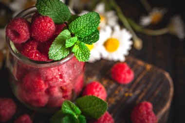 Karanlık bir arka plan üzerinde bir Fincan Ahududu. Yaz ve sağlıklı gıda konsepti. Seçici odak. Dikey.