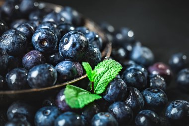 Rustik masada yeşil yaprakları ile sulu ve taze yaban mersini. Yaban mersini antioksidan. Sağlıklı yeme ve beslenme kavramı. Seçici odak.