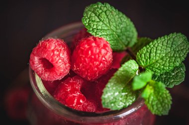 Karanlık bir arka plan üzerinde bir Fincan Ahududu. Yaz ve sağlıklı gıda konsepti. Seçici odak. Dikey.