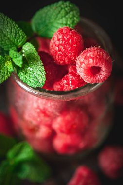 Karanlık bir arka plan üzerinde bir Fincan Ahududu. Yaz ve sağlıklı gıda konsepti. Seçici odaklama.