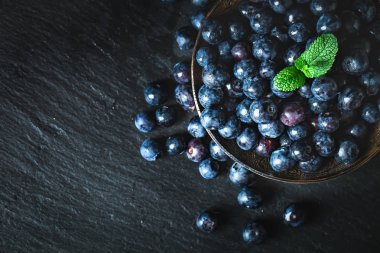 Rustik masada yeşil yaprakları ile sulu ve taze yaban mersini. Yaban mersini antioksidan. Sağlıklı yeme ve beslenme kavramı. Seçici odak.