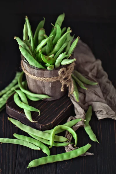 Frijoles verdes frescos en una mesa de madera. Verano y concepto de comida saludable. Enfoque selectivo . — Foto de Stock