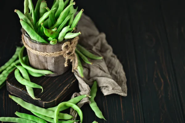 Frijoles verdes frescos en una mesa de madera. Verano y concepto de comida saludable. Enfoque selectivo. Fondo con espacio de copia . — Foto de Stock