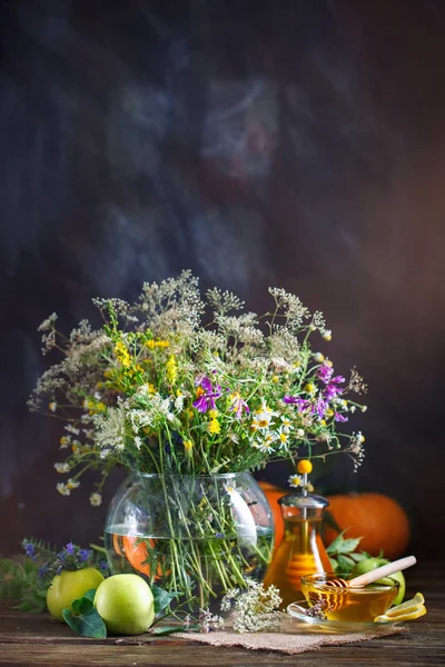 Miel fresca, flores de campo y manzanas maduras en una mesa de madera . — Foto de Stock