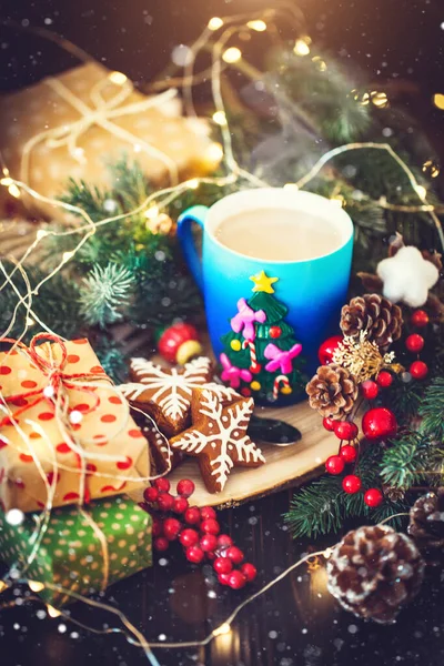 Ένα φλιτζάνι ζεστό κακάο και χριστουγεννιάτικα μπισκότα στο παρασκήνιο των χριστουγεννιάτικων γιρλάντες. Καλά Χριστούγεννα και καλή χρονιά. Επιλεκτική εστίαση. — Φωτογραφία Αρχείου