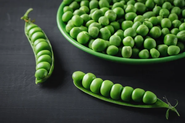 木製のテーブルの上に横たわるおいしい熟した緑のエンドウ豆. — ストック写真