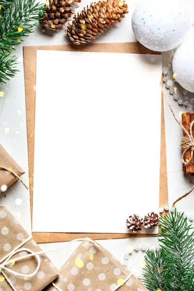 Mutlu Noeller ve mutlu yıllar. Kartpostallı bir model ve beyaz arka planda bir Noel ağacı dalları. Fotokopi alanı olan bir arka plan. Seçici odaklanma. Üst Manzara. Noel arkaplanı.