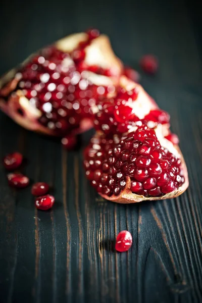 Fruta de granada madura sobre un antiguo fondo vintage de madera negra. Fondo con espacio de copia . — Foto de Stock