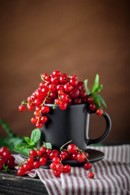 Koyu kırsal ahşap masada taze kırmızı frenk üzümü. Kopya alanı olan bir arkaplan. Seçici odak.