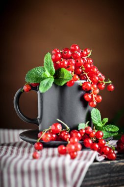 Koyu kırsal ahşap masada taze kırmızı frenk üzümü. Kopya alanı olan bir arkaplan. Seçici odak.