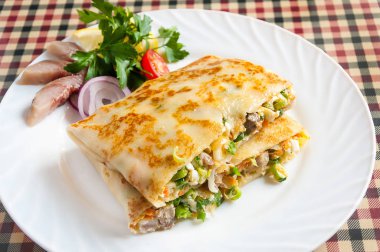 Ringa balığı ve beyaz bir tabakta sebze ile sıcak gözleme