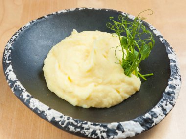 patates püresi ile mikro-Yeşiller karanlık bir plaka üzerinde