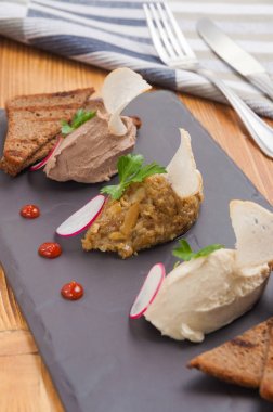 bir taş Tahta üzerinde ızgara çavdar ekmeği ile pate çeşitli üç çeşit