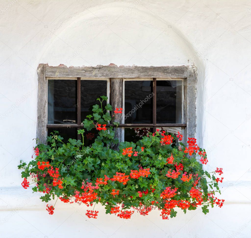 Vintage window of an historic old house, decorated with flowers
