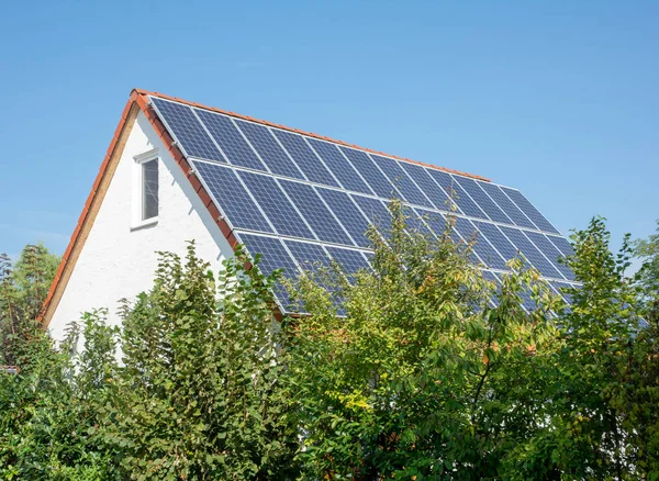 代替エネルギー生産のための屋根の上に太陽電池付きの近代的な家 — ストック写真
