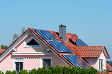 Alternatif enerji üretimi için çatıda fotovoltaik güneş pilleri olan modern ev