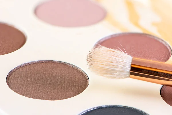 Closeup of a makeup palette for skin tones and brush