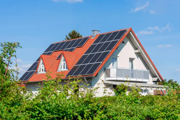 Alternatif enerji üretimi için çatıda fotovoltaik güneş pilleri olan modern ev