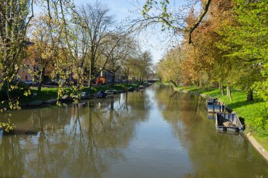 Utrecht 'teki kanal ya da Singel. Güneşli bir bahar günü, ağaçlar ve teknelerle dolu Hollanda.