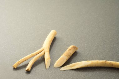 Gri bir taş masadaki yaban turpunun köklerini kapat