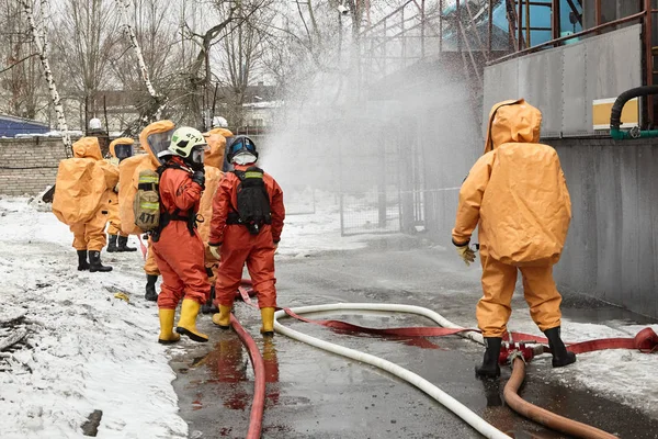 Kurtarma ekipleri kapsül takım elbiseli bir su engel toksik Ajan bulutu yolda koymak.