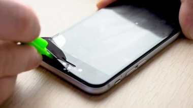 Akıllı telefon ekranından kırık koruma camını çıkarıyorum. 50 fps yavaş çekim.