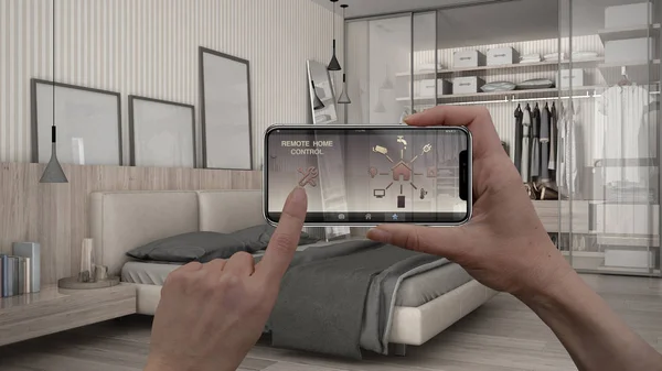 Remote home control system on a digital smart phone tablet. Device with app icons. Interior of minimalist white bedroom in the background, architecture design.