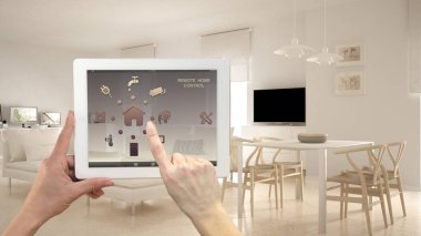 Akıllı uzaktan ev kontrol sistemi dijital tablet. Aygıt app simgeleri ile. Minimalist modern aydınlık oturma odası arka planda, mimari iç tasarım